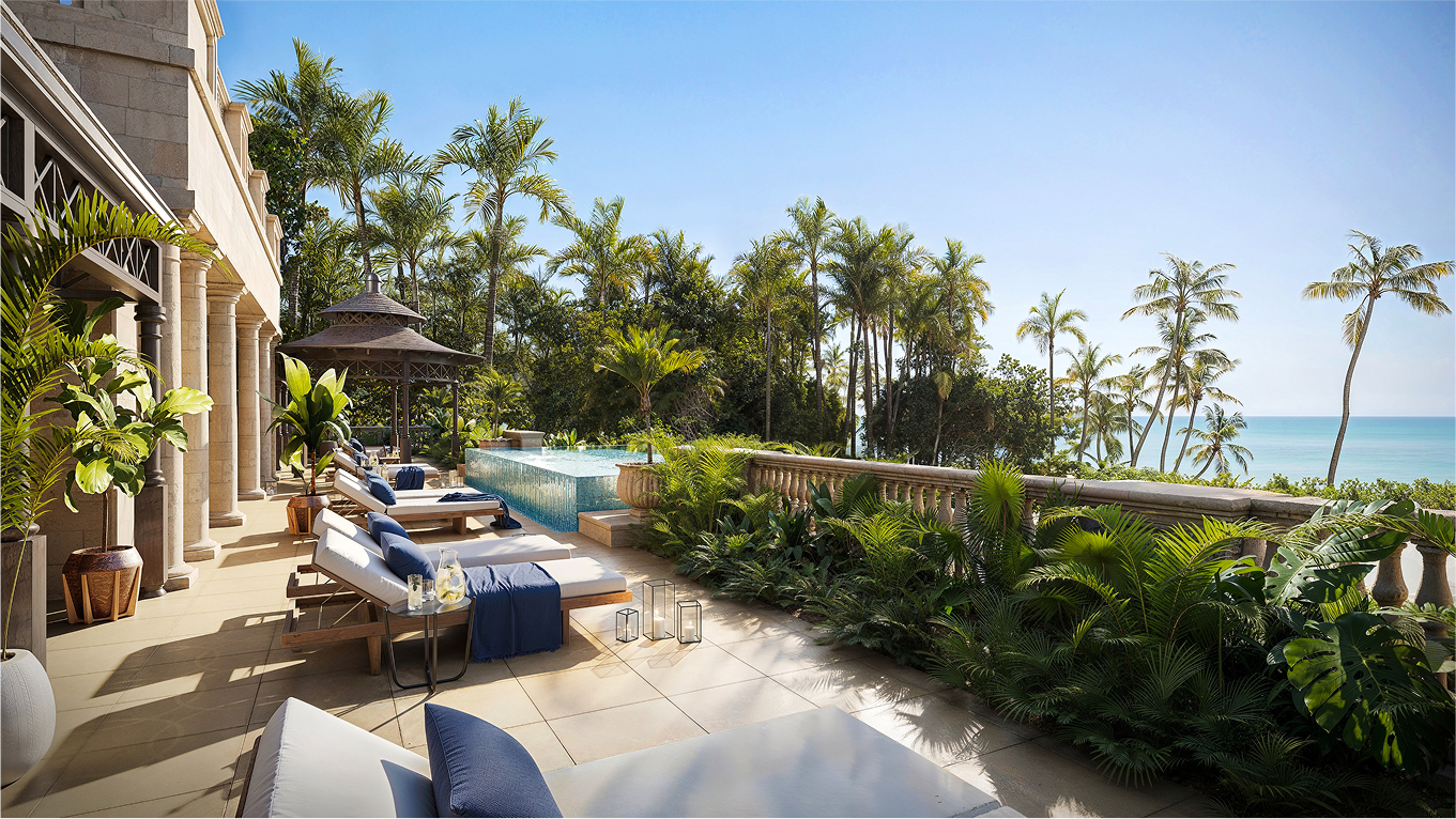 Luxury oceanfront patio at the Emerald Chateau with infinity pool and lounge chairs.