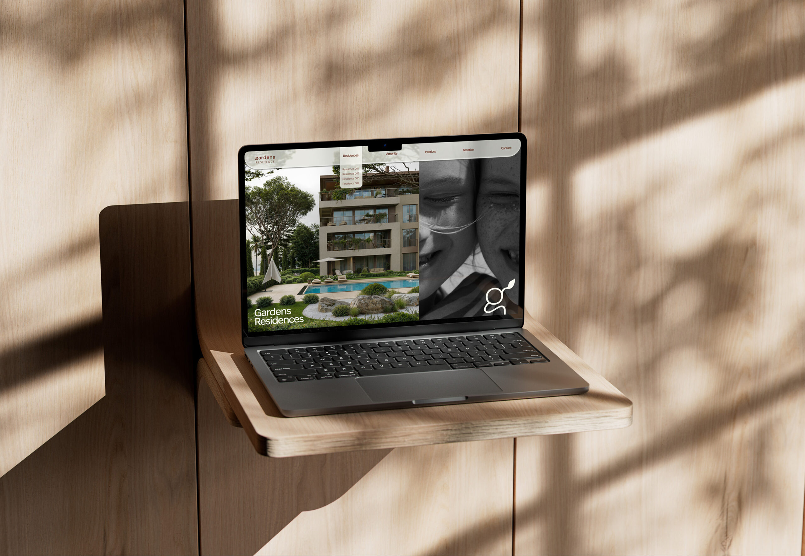 Laptop displaying Gardens Residences website; showcasing modern apartments and pool.