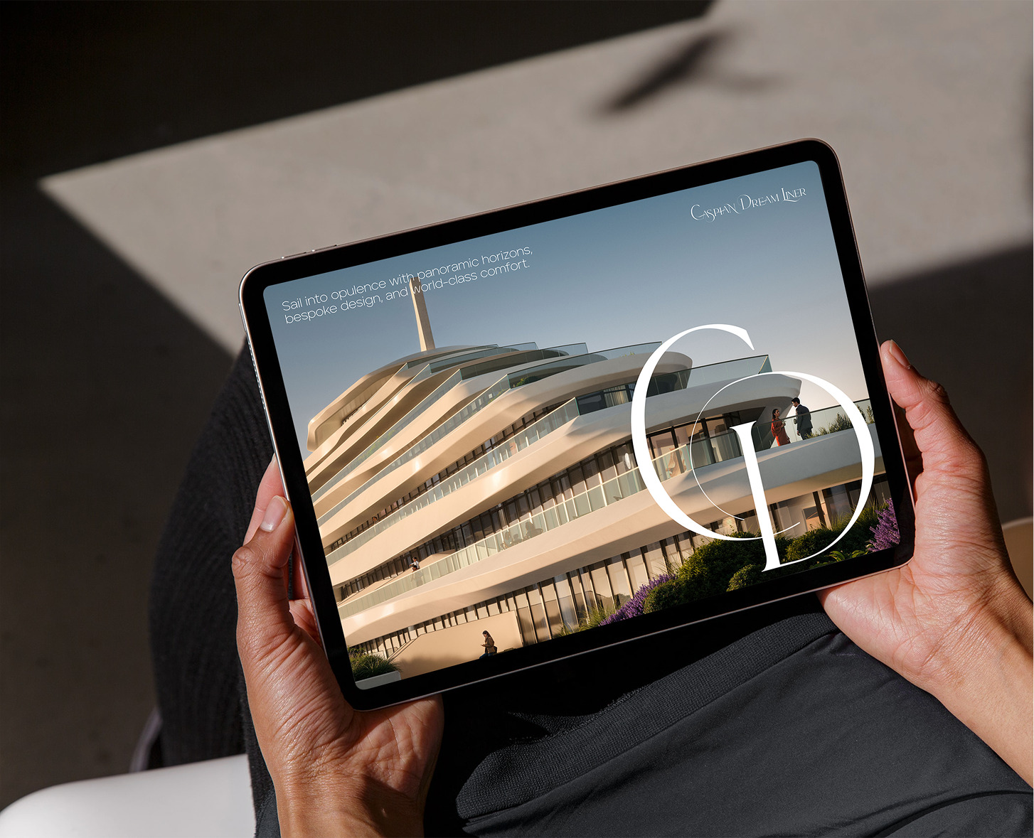 Hands holding tablet showing Caspian Dream Liner; luxury building with panoramic views.