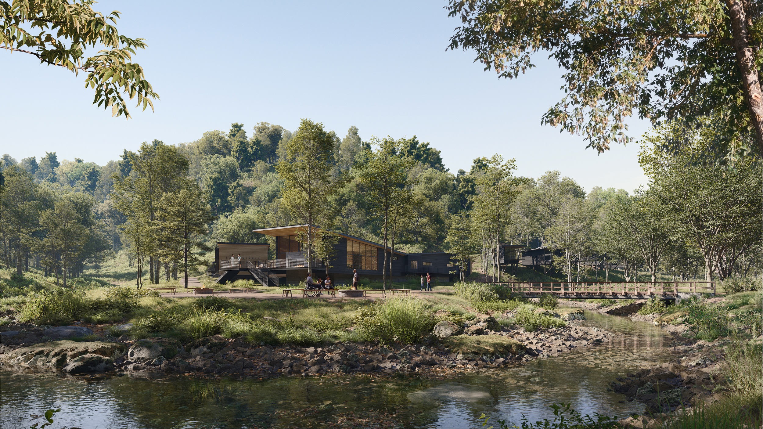 Camp Mikell: Modern cabins nestled in a wooded area near a creek and footbridge.