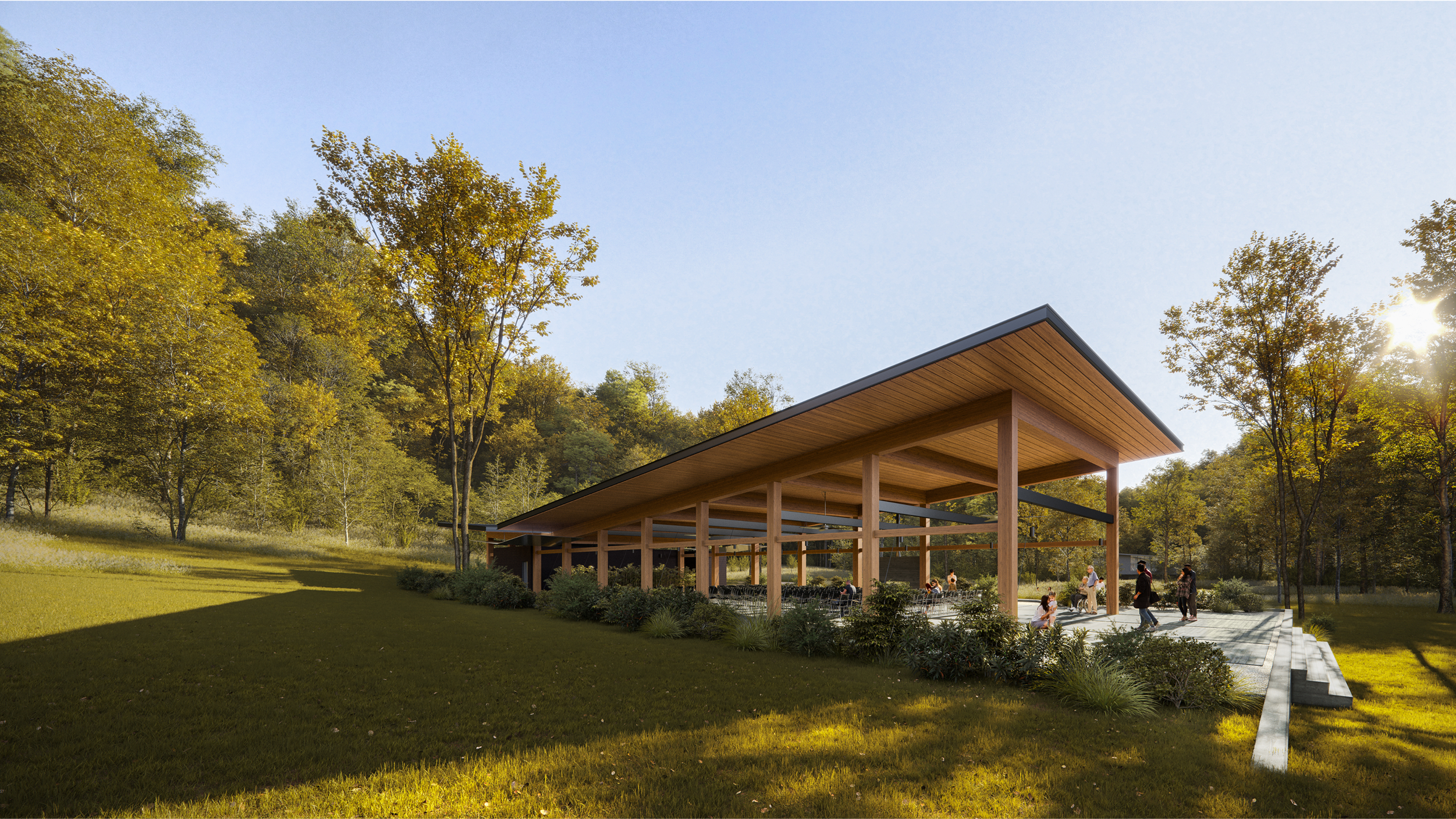 Modern wooden pavilion at Camp Mikell, surrounded by autumn trees and people enjoying the space.
