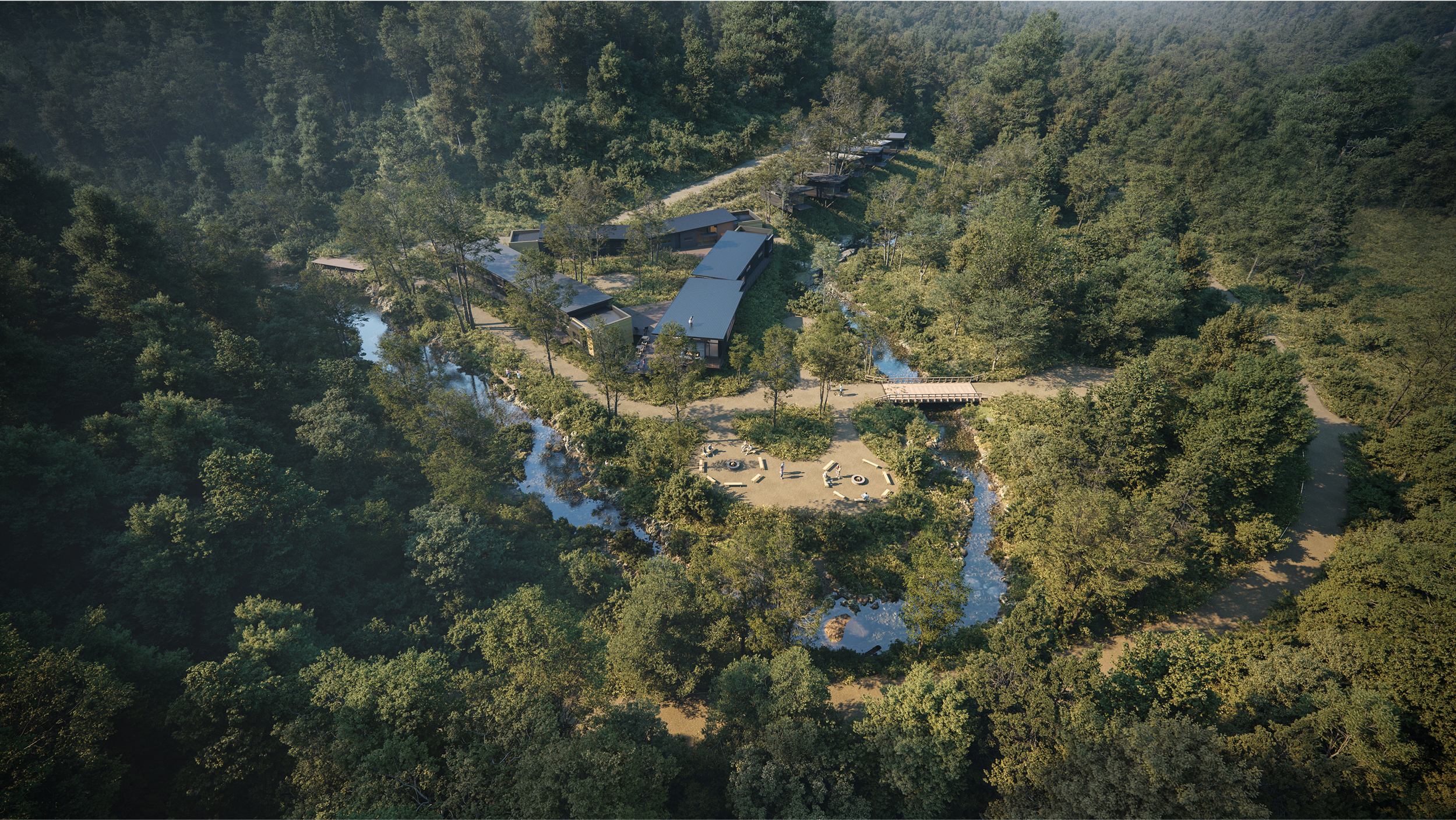 Aerial view of Camp Mikell nestled in lush forest landscape with winding stream