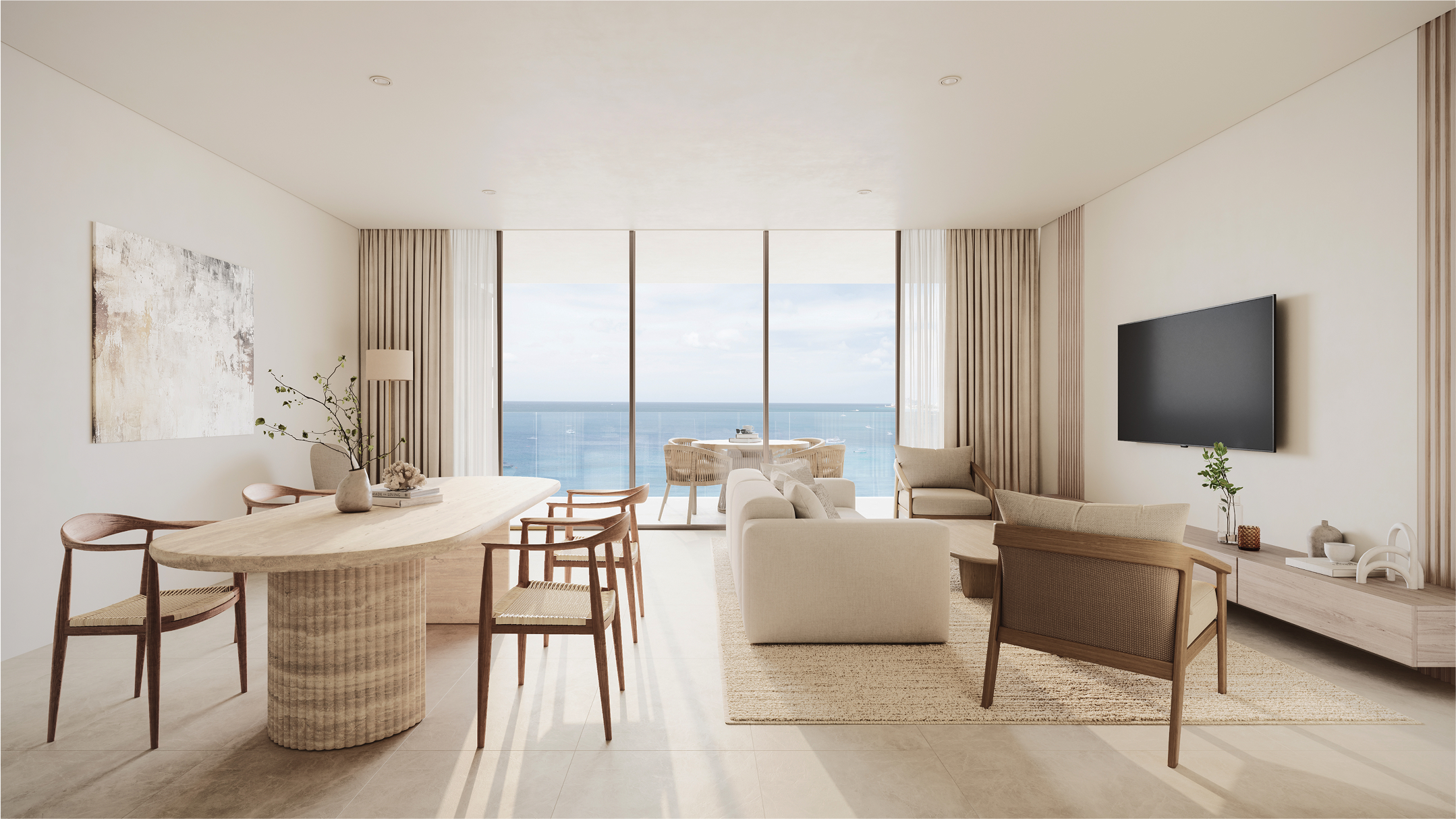 Modern living space at One Carlisle Bay with ocean views, featuring a dining table and comfortable seating.