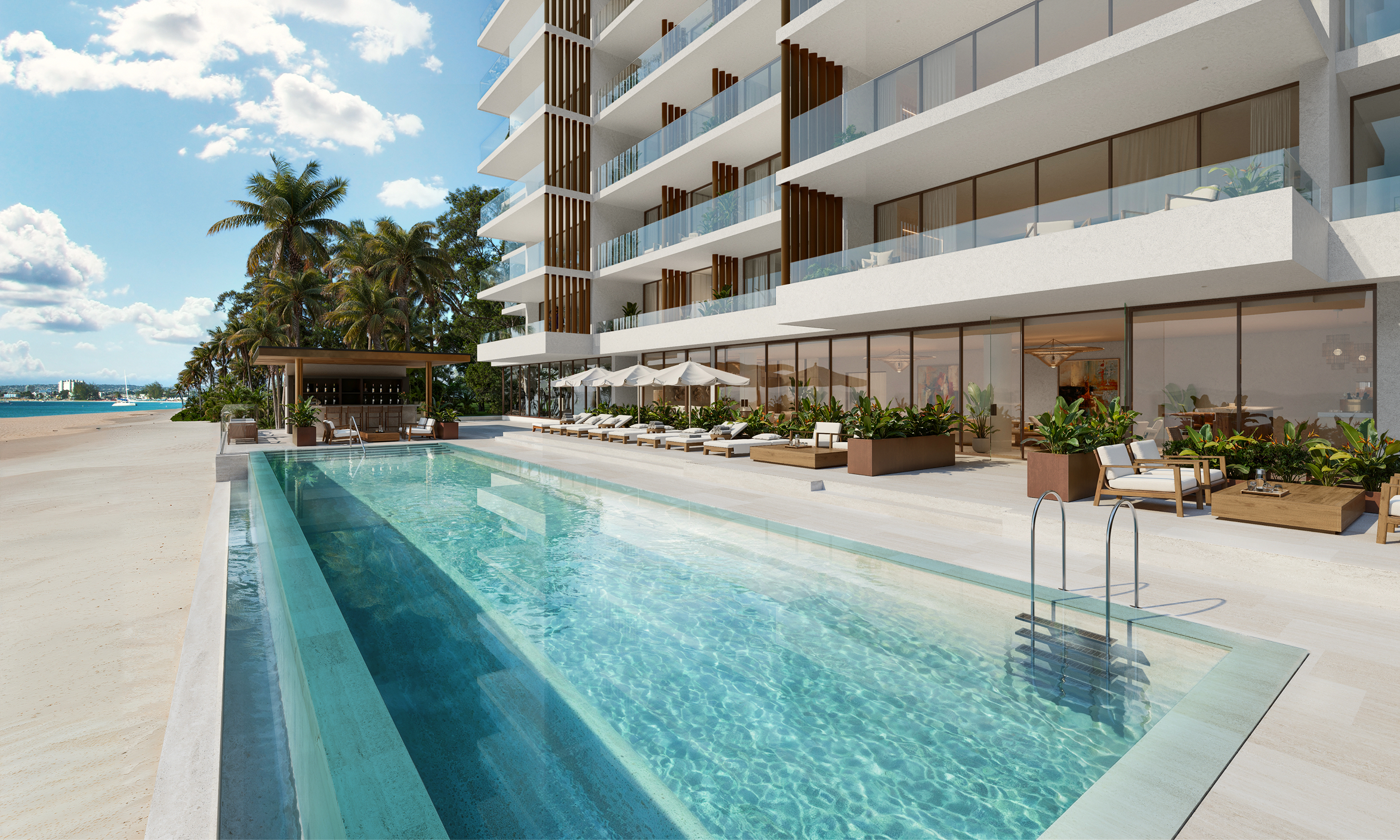 Luxury beachfront pool at One Carlisle Bay, featuring a modern building and tropical landscaping.