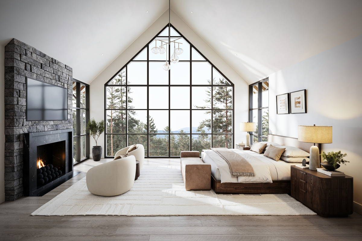 Luxurious bedroom with large windows overlooking Idaho mountains, featuring a stone fireplace and comfortable seating.